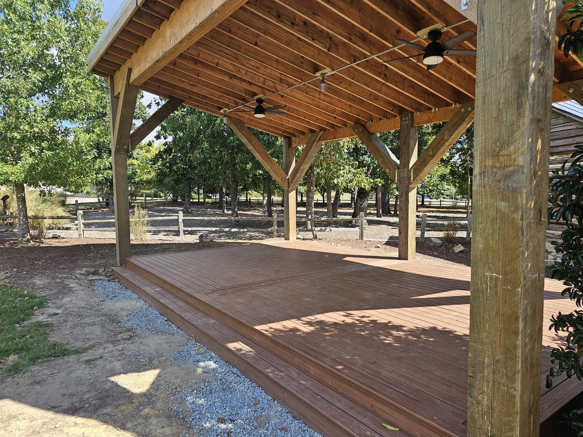 Covered porch with composite deck boards, timber posts and ceiling fans built by Haus Construction